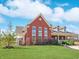 Beautifully designed red brick home with large windows and lush green lawn under a bright sky at 11315 N Quillow Way, Monrovia, IN 46167