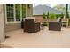 Outdoor seating area on a back porch featuring two chairs and a table with a manicured lawn in the background at 11780 Pebblepointe Pass, Carmel, IN 46033