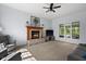 Cozy living room featuring a brick fireplace and large windows with natural light at 11780 Pebblepointe Pass, Carmel, IN 46033