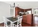 Cozy dining area with a modern chandelier, adjacent to a kitchen with dark wood cabinets at 127 Coatsville Dr, Westfield, IN 46074