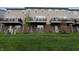 Townhome backyard featuring a lush green lawn, brick facade, and balconies above walkout basements at 14226 Frostburg Dr, Carmel, IN 46033