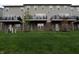 Townhome backyard featuring a lush green lawn, brick facade, and balconies above walkout basements at 14226 Frostburg Dr, Carmel, IN 46033
