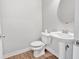 Bathroom featuring wood flooring, a pedestal sink, and a toilet at 14226 Frostburg Dr, Carmel, IN 46033