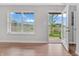 Bright living room featuring wood floors, neutral walls, and a view of the outdoors through a large window and open doorway at 14226 Frostburg Dr, Carmel, IN 46033