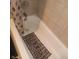 An elevated view of the tub shows a shower curtain, gray tiles, and a decorative bath mat at 1433 Charles St, Indianapolis, IN 46225
