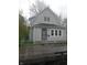 Charming two-story home featuring vinyl siding, well-maintained lawn, and a secure chain-link fence at 1433 Charles St, Indianapolis, IN 46225