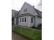 Charming two-story home with vinyl siding, well-maintained lawn, chain-link fence, and mature tree at 1433 Charles St, Indianapolis, IN 46225