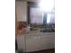 Galley kitchen showcasing a bright window, tiled backsplash, and essential appliances at 1433 Charles St, Indianapolis, IN 46225