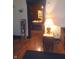 View of the living room leading to another room, featuring a lamp, bookcase, and hardwood floors at 1433 Charles St, Indianapolis, IN 46225