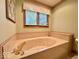 Relaxing bathroom with a jacuzzi tub, neutral tile, and decorative wallpaper border at 1544 Olive Branch Cir, Greenwood, IN 46143