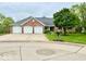 Charming brick home boasts a three-car garage and well-manicured lawn at 1544 Olive Branch Cir, Greenwood, IN 46143