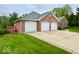 Brick home offers a three-car garage and a long driveway on a grassy lot at 1544 Olive Branch Cir, Greenwood, IN 46143