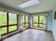 Cozy sunroom features large windows with backyard views, light blue walls, and vinyl flooring at 1544 Olive Branch Cir, Greenwood, IN 46143