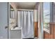 Bathroom featuring a shower, toilet, sink, window, and wood paneling at 1617 E Kelly St, Indianapolis, IN 46203