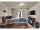 A simple bedroom with carpeted floors features a comfy bed, TV, and window at 1617 E Kelly St, Indianapolis, IN 46203