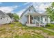 Quaint light-blue house features a fenced yard, small porch, and tree coverage for shade and privacy at 1617 E Kelly St, Indianapolis, IN 46203