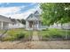 Quaint light-blue house features a fenced yard, small porch, and tree coverage for shade and privacy at 1617 E Kelly St, Indianapolis, IN 46203