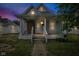 Cozy blue house boasting a covered front porch with columns and updated windows against a colorful sky at 1617 E Kelly St, Indianapolis, IN 46203