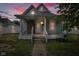 Cozy blue house boasting a covered front porch with columns and updated windows against a colorful sky at 1617 E Kelly St, Indianapolis, IN 46203
