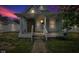 Cozy blue house boasting a covered front porch with columns and updated windows against a colorful sky at 1617 E Kelly St, Indianapolis, IN 46203
