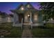 Cozy blue house boasting a covered front porch with columns and updated windows against a colorful sky at 1617 E Kelly St, Indianapolis, IN 46203