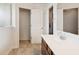 Bright bathroom with a white vanity top, tiled floors, and open doorway showing storage space at 16264 Red Clover Ln, Noblesville, IN 46062