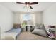 Inviting bedroom featuring a twin bed, beanbag chair, ceiling fan, and natural light from the window at 16264 Red Clover Ln, Noblesville, IN 46062