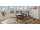 Bright dining area featuring wood floors, a wooden dining table, and large windows at 16264 Red Clover Ln, Noblesville, IN 46062