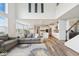 Open-concept living room showcasing high ceilings, wood floors, and a seamless flow to the kitchen at 16264 Red Clover Ln, Noblesville, IN 46062