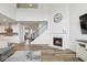 Open-concept living room featuring a fireplace, staircase, and seamless flow into the kitchen at 16264 Red Clover Ln, Noblesville, IN 46062