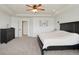 Spacious main bedroom featuring plush carpeting, tray ceiling, a dresser, and a ceiling fan at 16264 Red Clover Ln, Noblesville, IN 46062