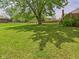 Expansive backyard featuring lush lawn, mature trees, and privacy fence, creating a serene outdoor space at 1645 Woodview Ln, Anderson, IN 46011