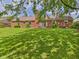 Lush backyard with a brick house featuring a chimney, sliding glass doors and mature trees at 1645 Woodview Ln, Anderson, IN 46011