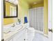 Bathroom with yellow walls featuring vanity, toilet, shower with curtain, and tiled floors at 1645 Woodview Ln, Anderson, IN 46011