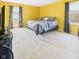 Brightly lit bedroom with yellow walls, gray bedding, plush carpet and television at 1645 Woodview Ln, Anderson, IN 46011