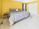 Bedroom with yellow walls, gray bedding, carpeted floor, and closet with sliding doors at 1645 Woodview Ln, Anderson, IN 46011