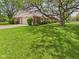 Charming brick home with large shade tree, grassy lawn, landscaping and attached garage at 1645 Woodview Ln, Anderson, IN 46011