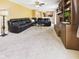 Spacious living room with carpet, a brick fireplace, built-in shelving, and a large black sectional sofa at 1645 Woodview Ln, Anderson, IN 46011
