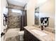 Bathroom featuring a granite countertop, tile shower, and dark fixtures and hardware at 1648 Rossmay Dr, Westfield, IN 46074