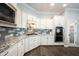 Modern kitchen with white cabinets, gray backsplash, and granite countertops at 1648 Rossmay Dr, Westfield, IN 46074