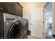 Modern laundry room with side-by-side washer and dryer, overhead cabinets, and a convenient layout for laundry tasks at 1648 Rossmay Dr, Westfield, IN 46074