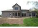 A view of the home's rear elevation with brick, a walkout patio, and a landscaped yard at 17003 Whitebark Ct, Westfield, IN 46074