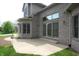 Rear exterior featuring brick, large windows, and a stone patio at 17003 Whitebark Ct, Westfield, IN 46074