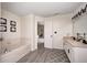 Bright bathroom features double vanity, soaking tub with flower art, and doorway to bedroom at 1831 Whisperwood Trl, Danville, IN 46122