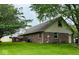 Expansive backyard view of a brick home with a wood deck and mature trees at 1934 Constitution St, Greenfield, IN 46140