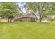 A lush green backyard featuring mature trees, a wooden deck, and ample space at 1934 Constitution St, Greenfield, IN 46140