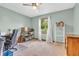 Cozy bedroom with light green walls, carpet, and a window with a view of the trees at 1934 Constitution St, Greenfield, IN 46140