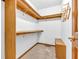 Walk-in closet with wooden shelving, carpet flooring, and ample storage space for wardrobe organization at 1934 Constitution St, Greenfield, IN 46140