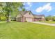 Home's front exterior features a well-manicured lawn and attached two car garage at 1934 Constitution St, Greenfield, IN 46140