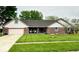 Charming brick ranch home with a well-manicured lawn and inviting covered front porch at 1934 Constitution St, Greenfield, IN 46140